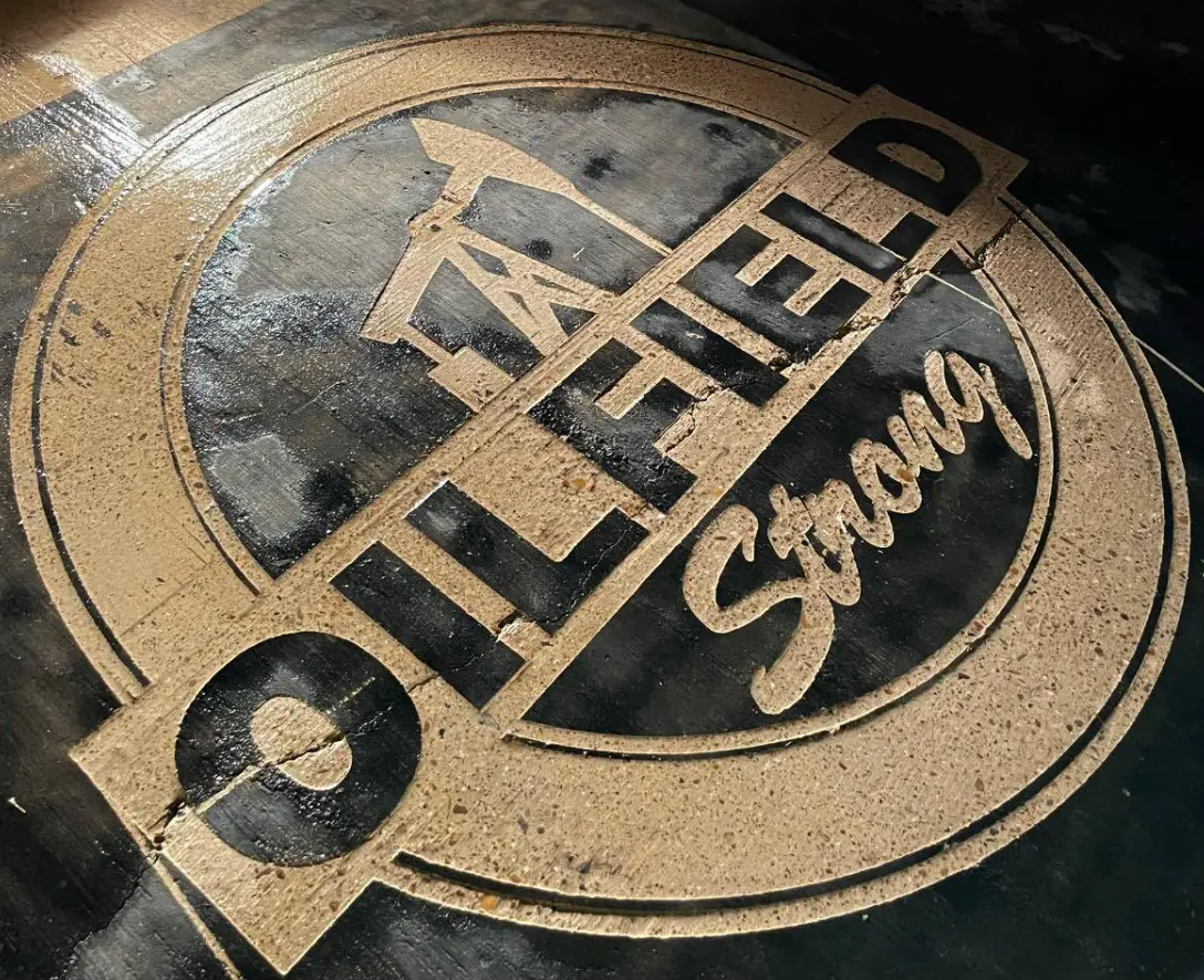 Oilfield Strong emblem engraved into a dark polished floor