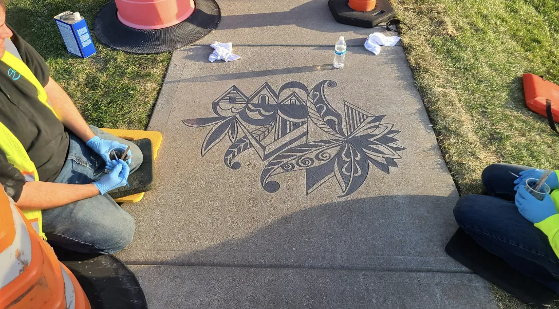 Decorative pattern being engraved into a sidewalk