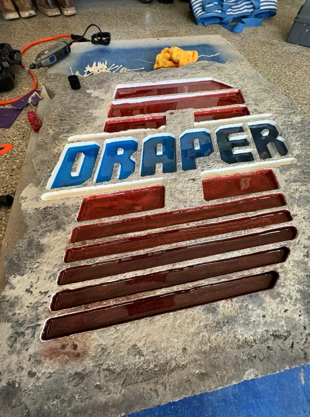 Draper flag design engraved and color-filled into a stone slab