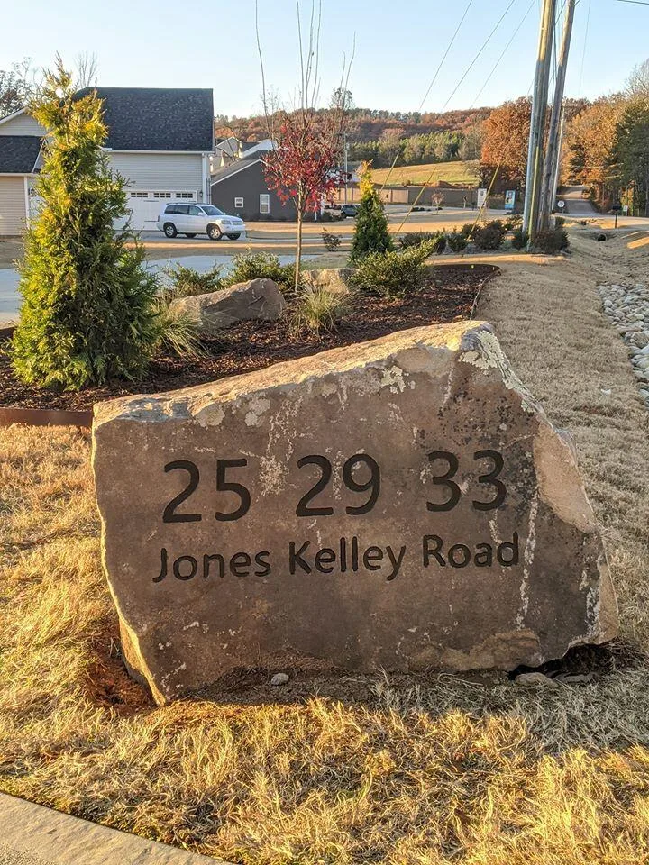 Owner standing with a freshly engraved boulder