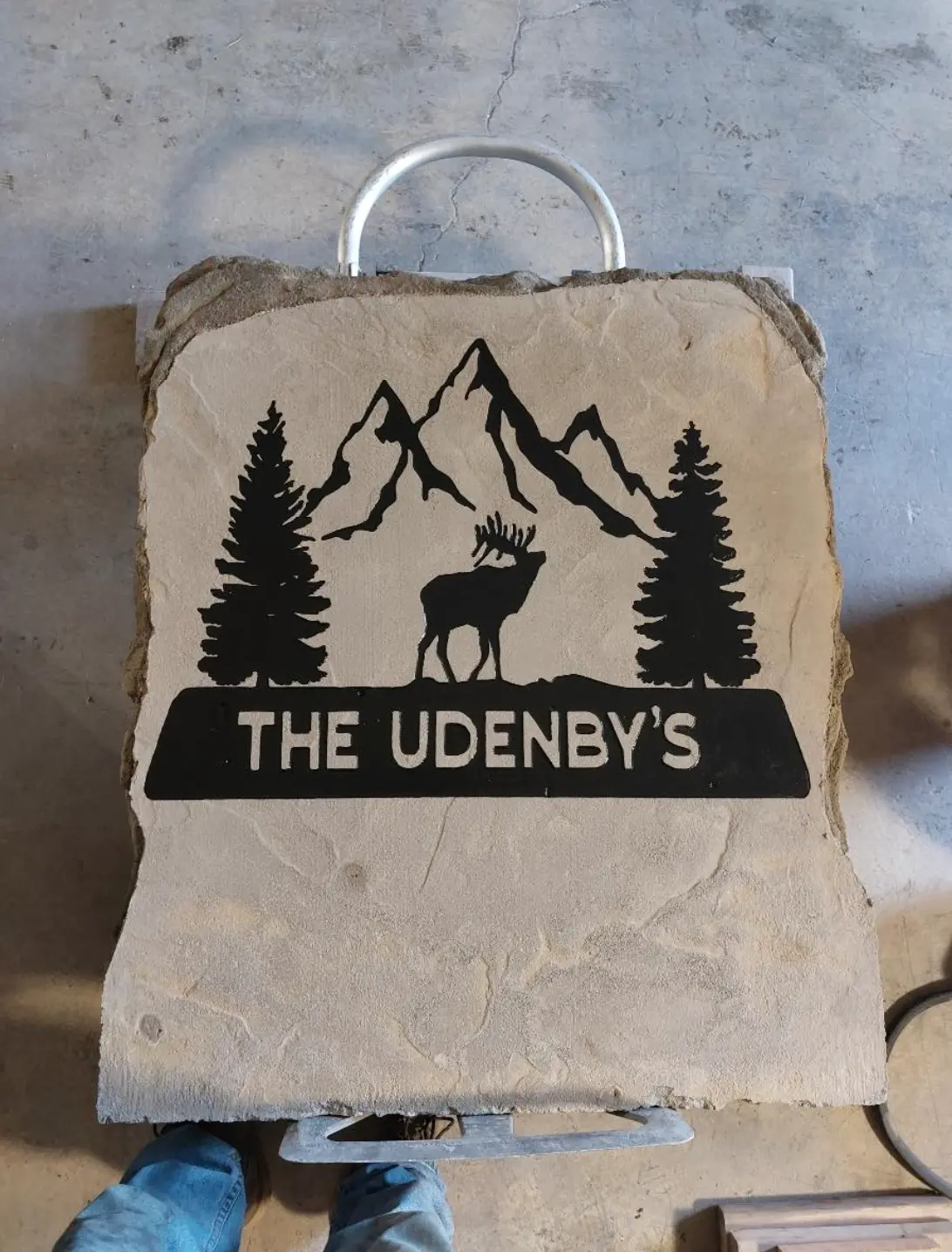 The Udenby's engraved mountain and elk scene on a stone sign